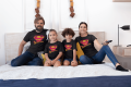 t-shirt-mockup-of-a-family-of-four-watching-tv-on-a-bed-28061.png