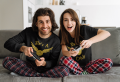 sweatshirt-and-t-shirt-mockup-of-a-happy-couple-on-a-couch-with-gaming-controllers-m21084-r-el2.png